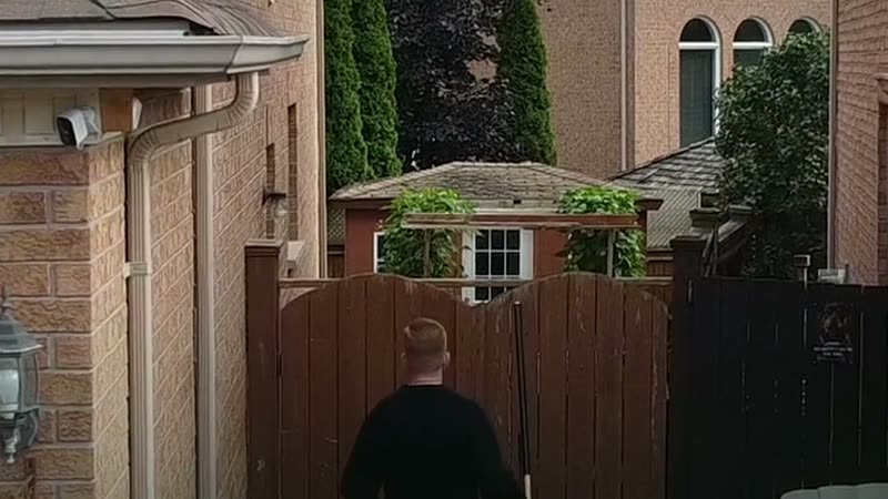 A technician photographing a closed side gate after a visit